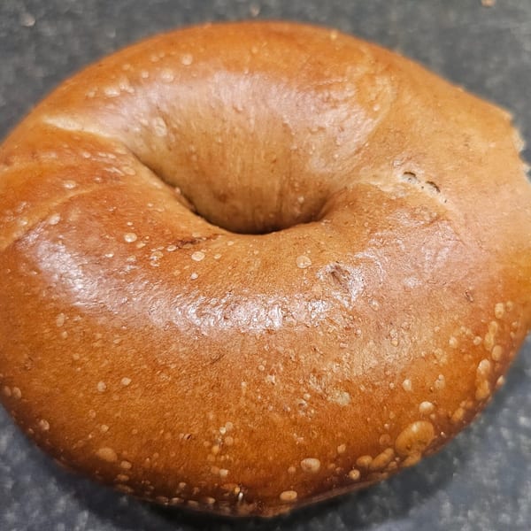 A freshly baked, golden-brown bagel from Bagels N' Cream, ready to be enjoyed.