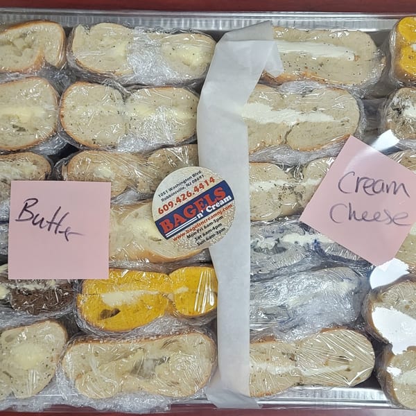 A tray of Bagels N' Cream bagels, some with butter and others with cream cheese, individually wrapped.