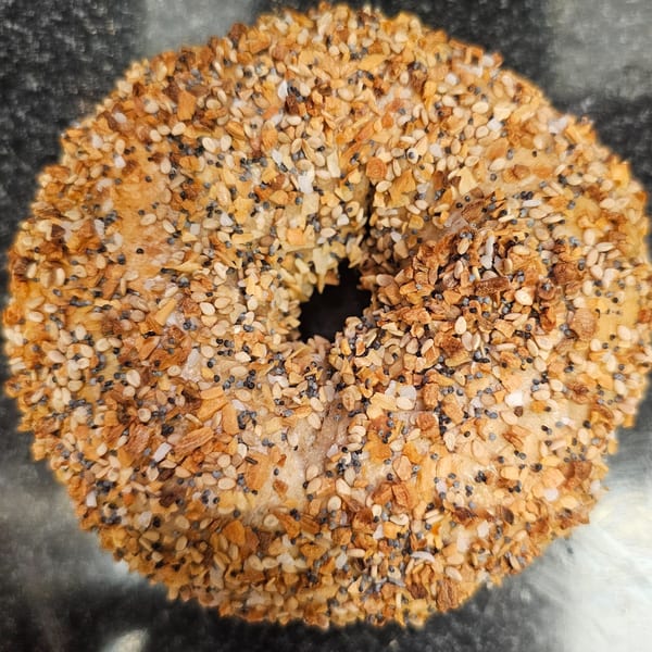 Close-up of an everything bagel from Bagels N' Cream, topped with seeds and spices.
