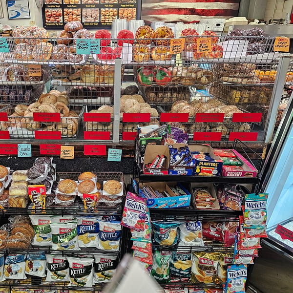 A display case at Bagels N' Cream filled with various bagels, muffins, and snacks.