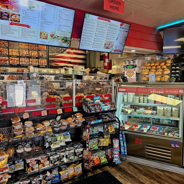 A wide shot of the Bagels N' Cream interior, showcasing various bagels, muffins, chips, and cream cheeses.